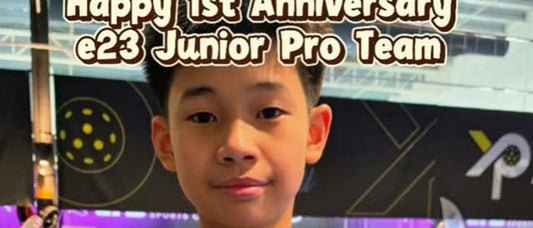 Elton Liew, holding a red e23 paddle in a clip marking one year on the e23 Junior Pro Team