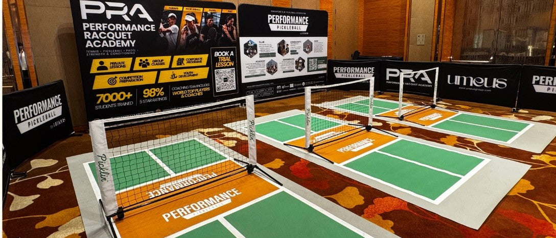 The mini court setup beside Performance Racquet Academy's display boards.