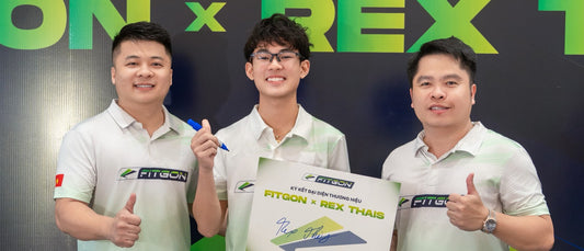 Rex Thais, holding the signed Fitgon x Rex Thais board between two men in Fitgon polos.