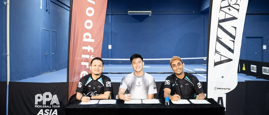 Timothy Foo's signing event, with three people seated at a table signing documents between the Woodfire and Kazza banners.