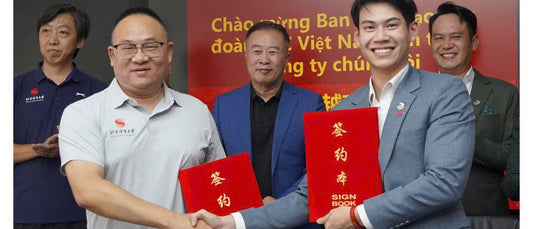 Dang Quang Anh, D-Joy chairman, shakes hands with a Beijing Sport University representative at the signing in Beijing.