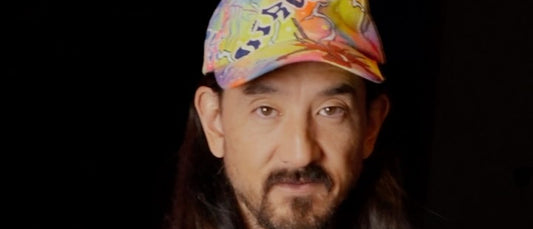 Steve Aoki in a colourful cap, holding two table tennis rackets in JOOLA's launch Reel.