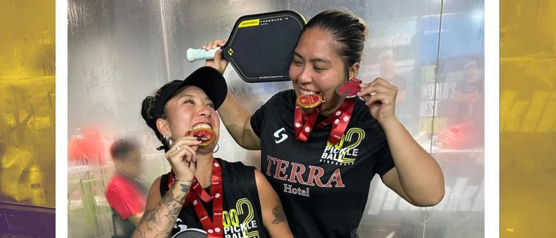 Neem Shamsuddin and Jas Almaguer biting their medals at the Franklin Singapore Pickleball Open